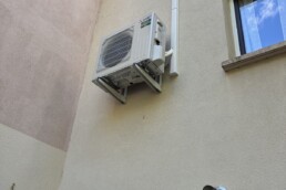 Groupe extérieur Mitsubishi Electric SUZ-M50 sur console murale, liaisons en goulotte blanche – climatisation gainable à Francheville – Fontherm